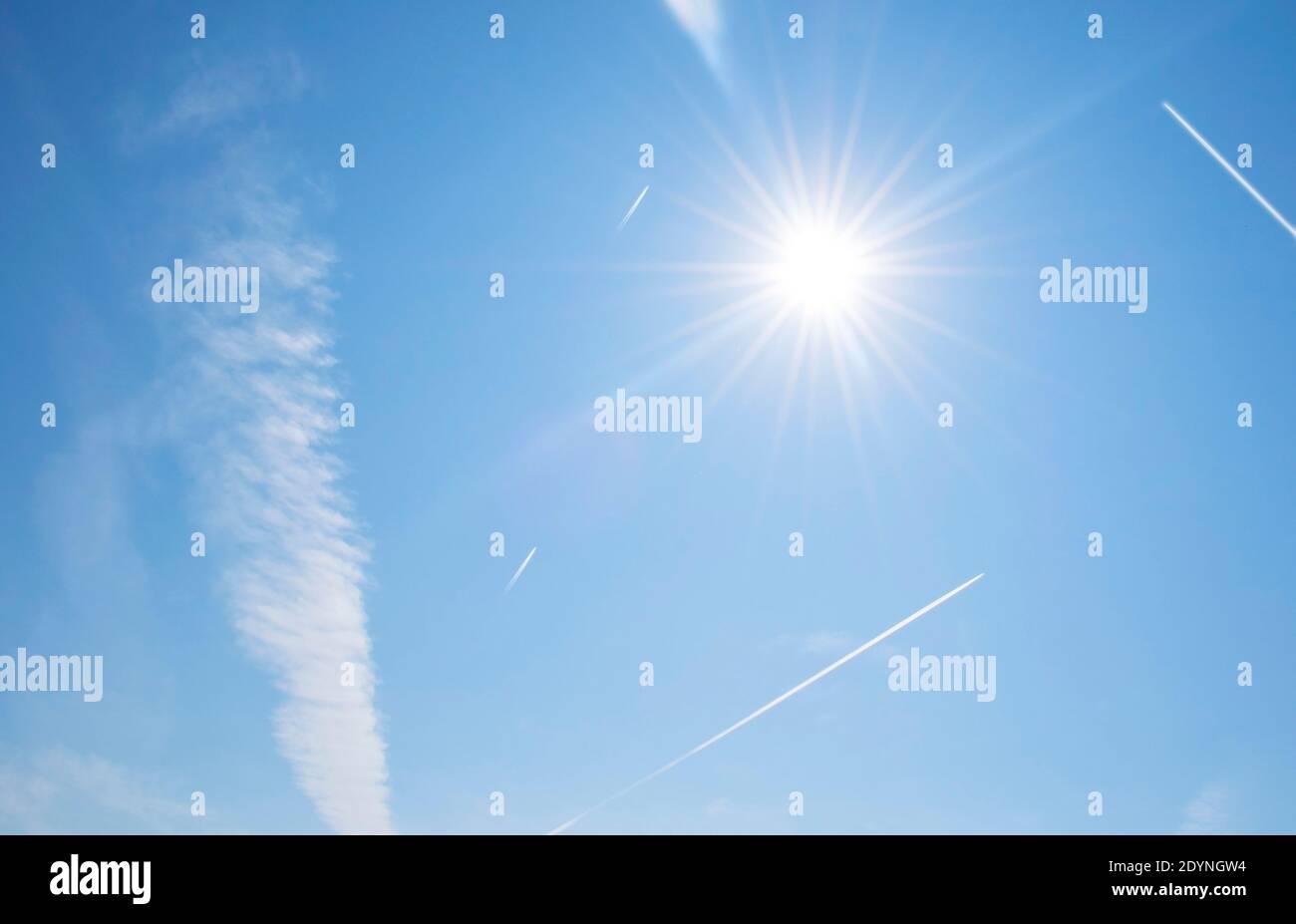 Chemtrails am Himmel an einem klaren, sonnigen Tag. Verschwörungstheorie Foto von Jetdampf und CO2-Fußabdruck von kommerziellen Flugzeugen gemacht. Viel Flugverkehr Stockfoto