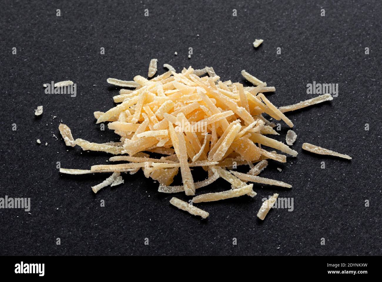 Geriebener Parmesankäse auf schwarzem Hintergrund, Parmigiano aus nächster Nähe Stockfoto