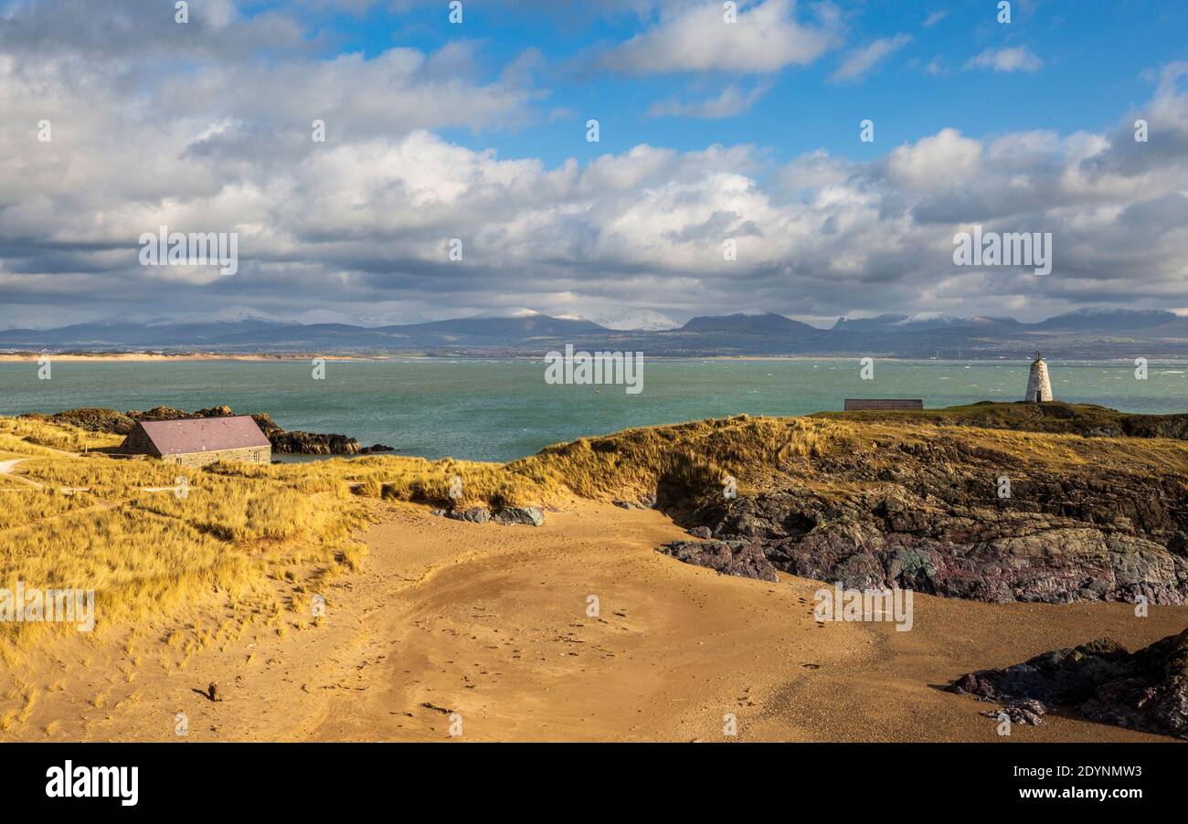 Ein Blick auf Twr Bach und die schneebedeckten Snowdonia Berge von Llanddwyn Insel, Anglesey Stockfoto