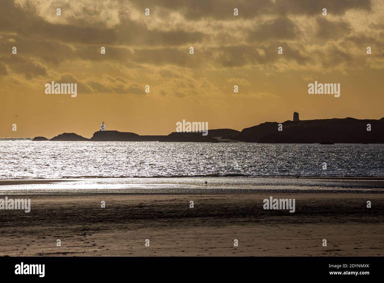 Eine Silhouette der Insel Llanddwyn und der Leuchttürme von Twy Bach und Twr Mawr vom Strand von Newborough, Anglesey Stockfoto