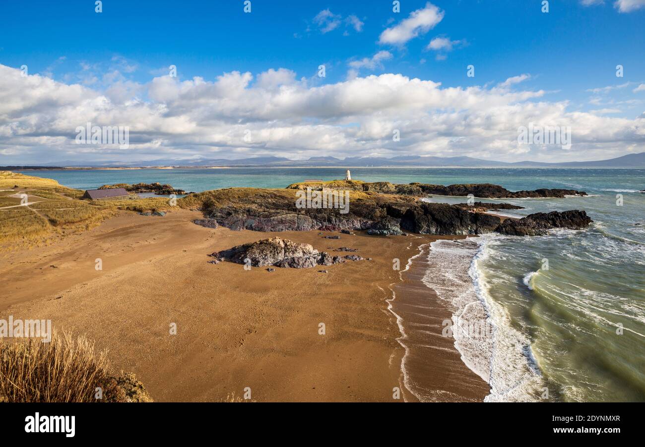 Ein Blick auf Twr Bach und die schneebedeckten Snowdonia Berge über Porth Twr Mawr auf Llanddwyn Island, Anglesey Stockfoto