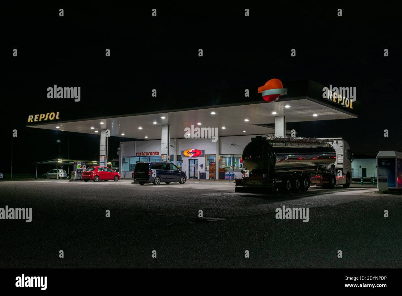 Repsol Ölgesellschaft Tankstelle mit einem Tankwagen und zwei Autos liefern Kraftstoff in der Nacht. Stockfoto