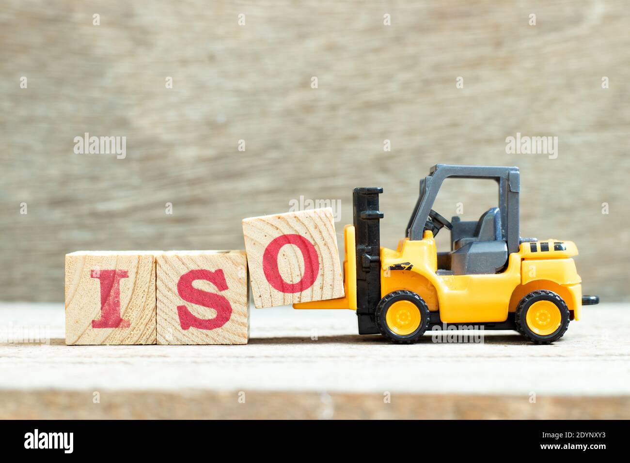 Spielzeug Gabelstapler halten Buchstaben Block o Wort iso zu vervollständigen Auf Holzhintergrund Stockfoto