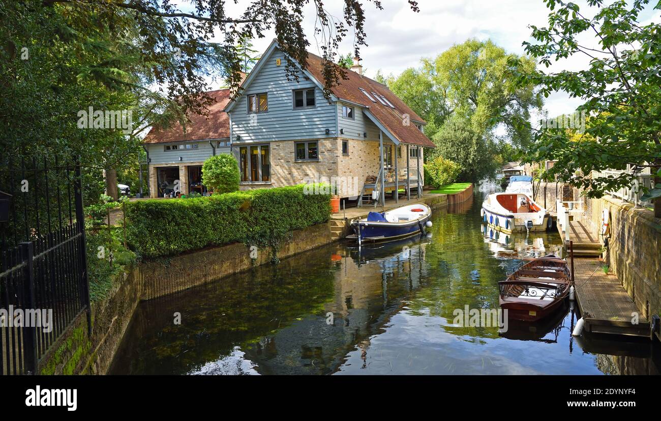 River Front Grundstück auf Stelzen mit Wasser und Boote im Vordergrund. Stockfoto