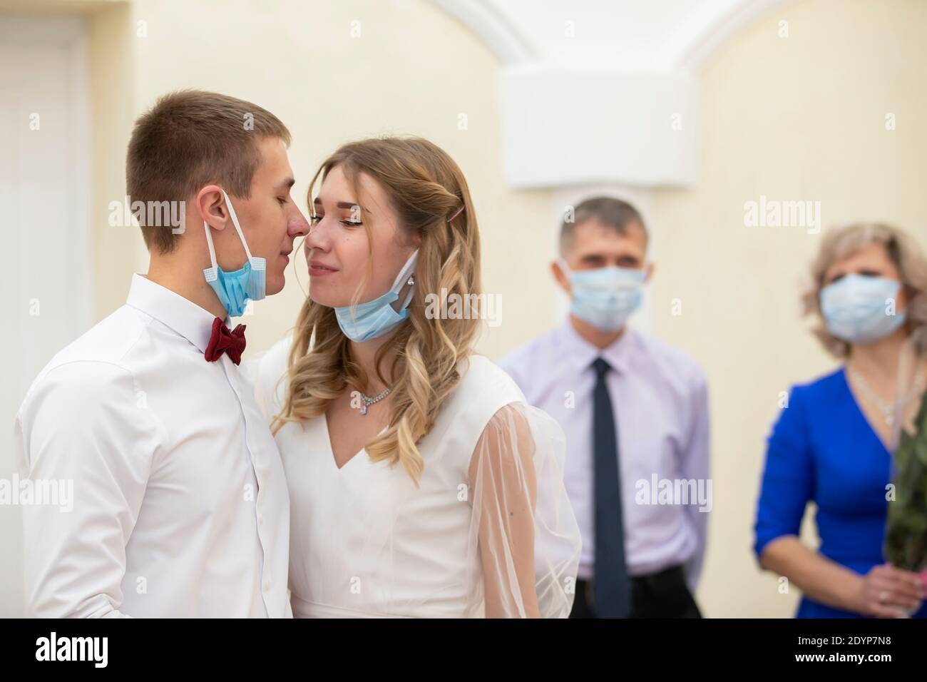 . Braut und Bräutigam trägt medizinische Masken. Hochzeit während der Coronavirus panademia. Heirat während der Stockfoto