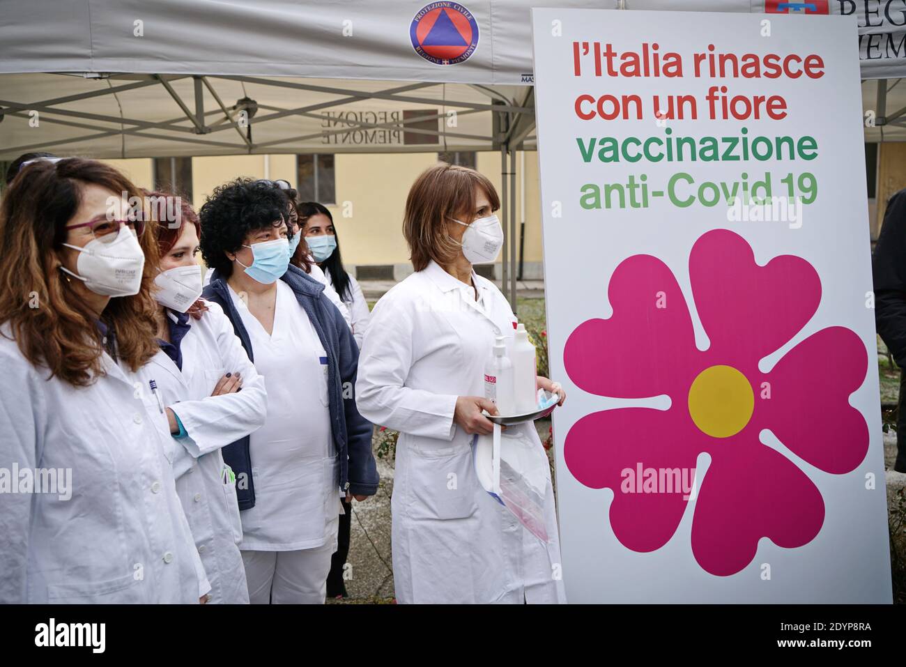 Gesundheitshelfer neben dem Primrose-Blumenplakat, dem Symbol der italienischen Impfkampagne COVID-19. Turin, Italien - 27. Dezember 2020 Stockfoto