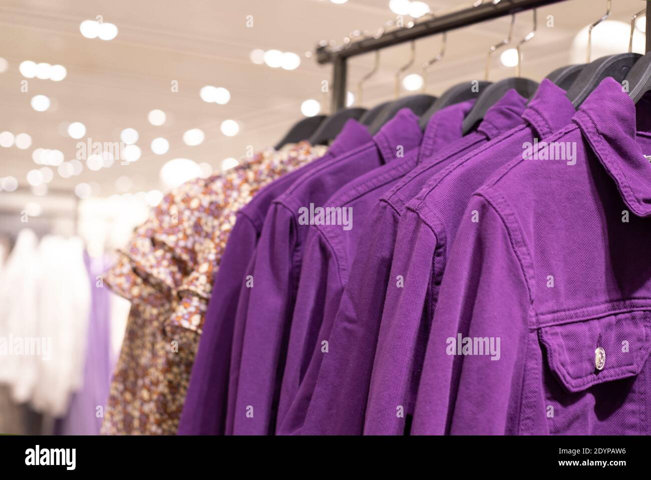 Damenbekleidung - Herbst Winter Kollektion. Denim Jacken auf Kleiderbügeln im Laden. Das Konzept des bewussten Verbrauchs und Recycling der Dinge. Stockfoto