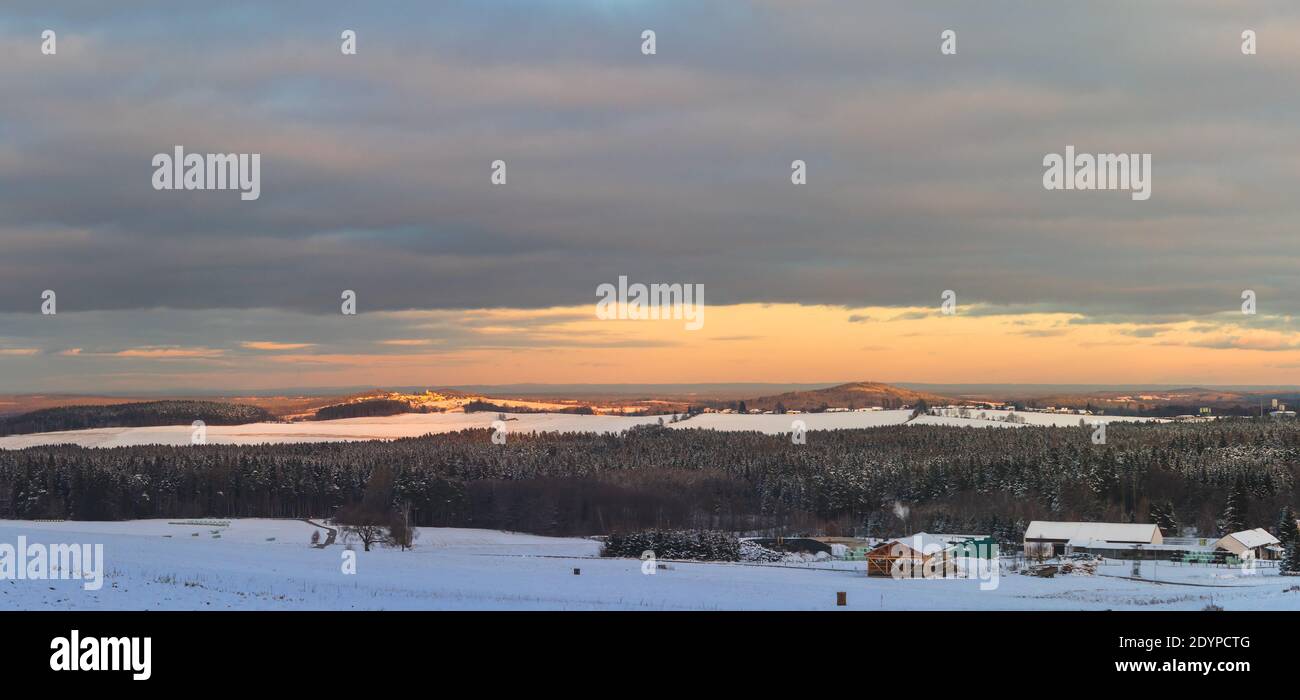 Winter verschneite Landschaft, mit Feldern, Wäldern und Hügeln, bei Sonnenuntergang Stockfoto