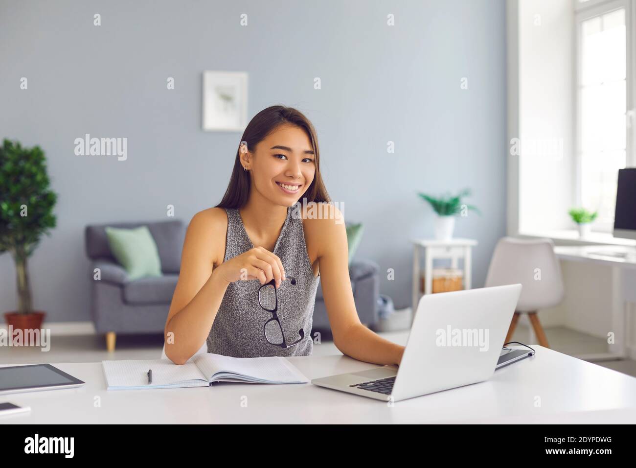 Lächelnd asiatische Frau Büroangestellte arbeiten in modernen geräumigen Büro Mit Laptop Stockfoto