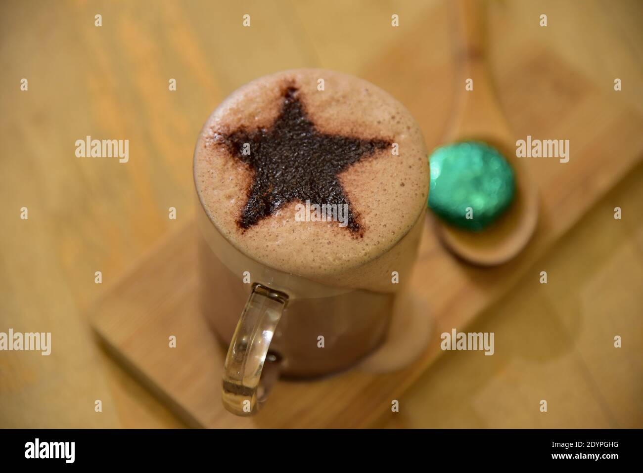 Weihnachten heiße Schokolade Thema mit einem festlichen Stern, präsentiert auf einem hölzernen Server komplett mit einer kostenlosen saisonalen verpackten Schokolade. Stockfoto
