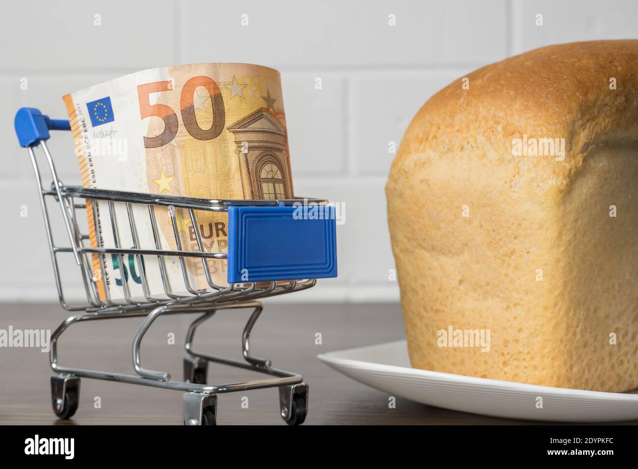 50 Euro in einem Lebensmittelkorb mit Brot. Steigende Lebensmittelpreise und Lebensmittel in Europa und anderen Ländern. Humanitäre Hilfe Stockfoto