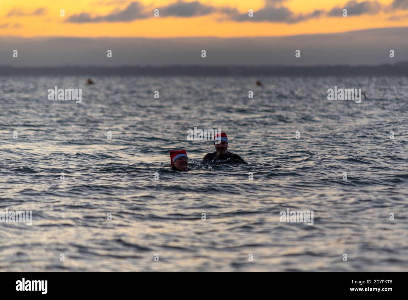 Kaltes Wasser Schwimmen in der Themse Mündung am Weihnachtstag Morgen in Southend on Sea, Essex, Großbritannien. Männer und Frauen tragen festliche Weihnachtsmützen Stockfoto