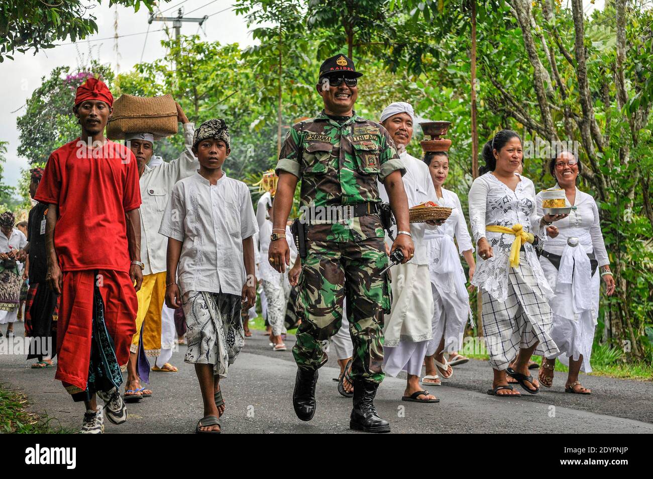 Ein lokaler lächelnder balinesischer Polizist führt die Menschen in den Städten während einer widerlichen Prozession an. Stockfoto