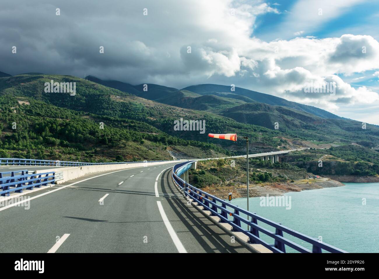 Verlängerter Windsack, der starken Wind anzeigt, auf einem Viadukt über einem Sumpf. Stockfoto