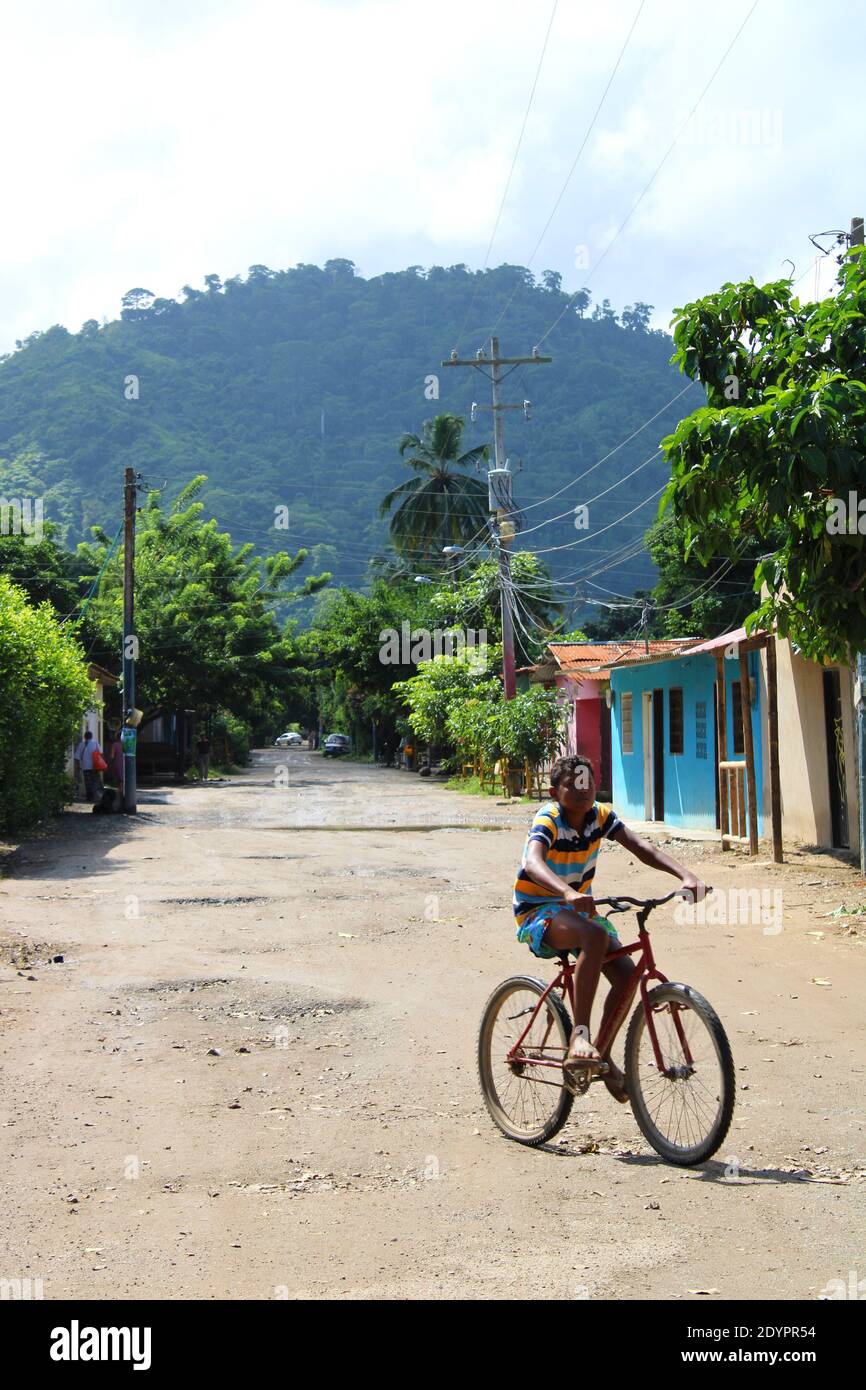 Junge fährt mit dem Fahrrad auf den Straßen seines Dorfes Stockfoto