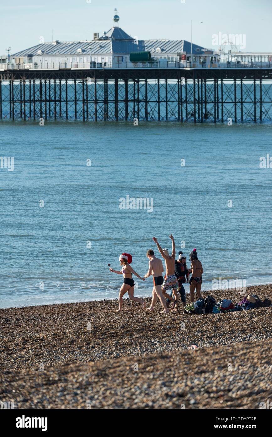 Brighton, East Sussex. Dezember 2020. Wetter in Großbritannien. Weihnachtstag am Brighton Beach, mit Weihnachtsmützen und tapferen Seeschwimmern, die die Kälte entblössen. Es gab ruhiges Meer und strahlend blauen Himmel, nur wenige Tage vor dem Sturm Bella, der nach dem Boxtag vorhergesagt wird. Stockfoto