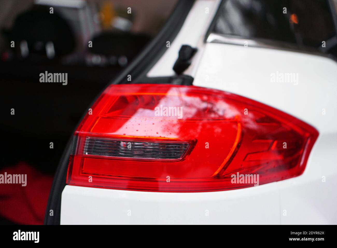 Weißes Auto mit rotem Scheinwerfer und offener Tür Stockfoto