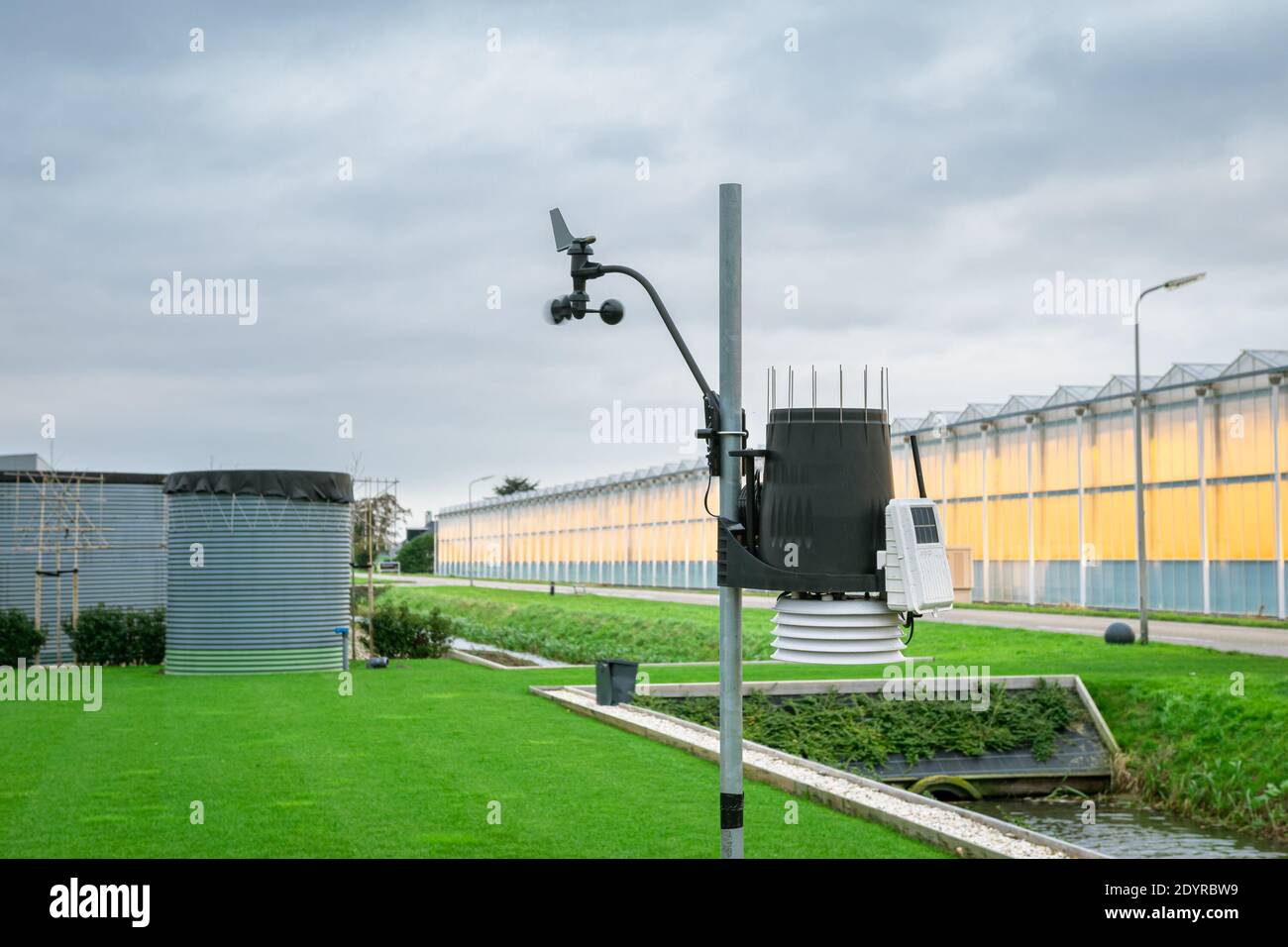Wetterstation zur Messung von Temperatur, Luftfeuchtigkeit und windgeschwindigkeit in einem Gewächshaus. Tassen Anemometer sind durch den Wind etwas unscharf. Stockfoto