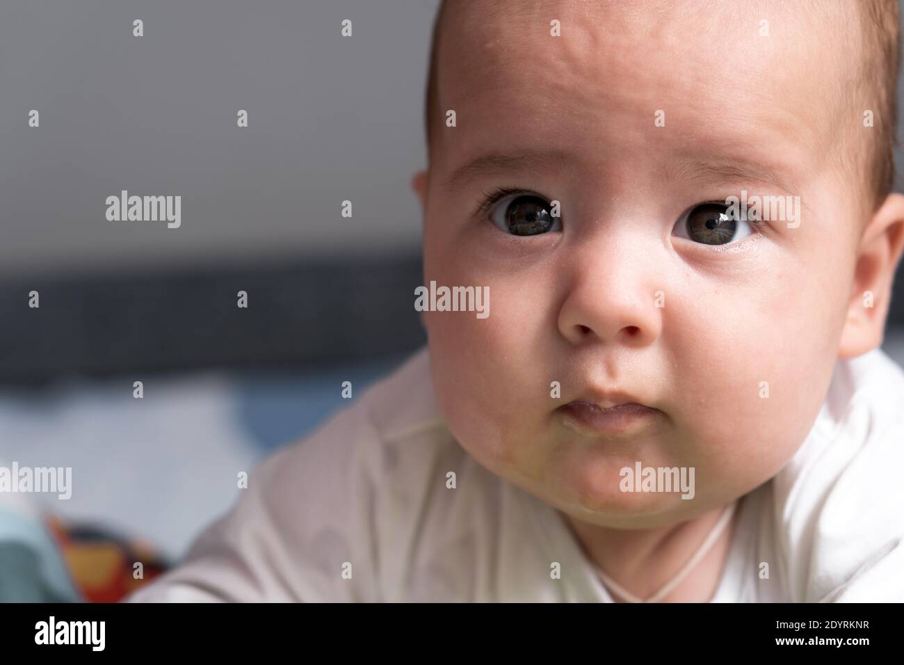 Kindheit, Glück, Mutterschaft Konzepte - Säugling überrascht, lustige neugeborene Kind Baby im Alter von 3-4 Monaten spielen mit Spielzeug, nagende Zahnstocher auf Stockfoto