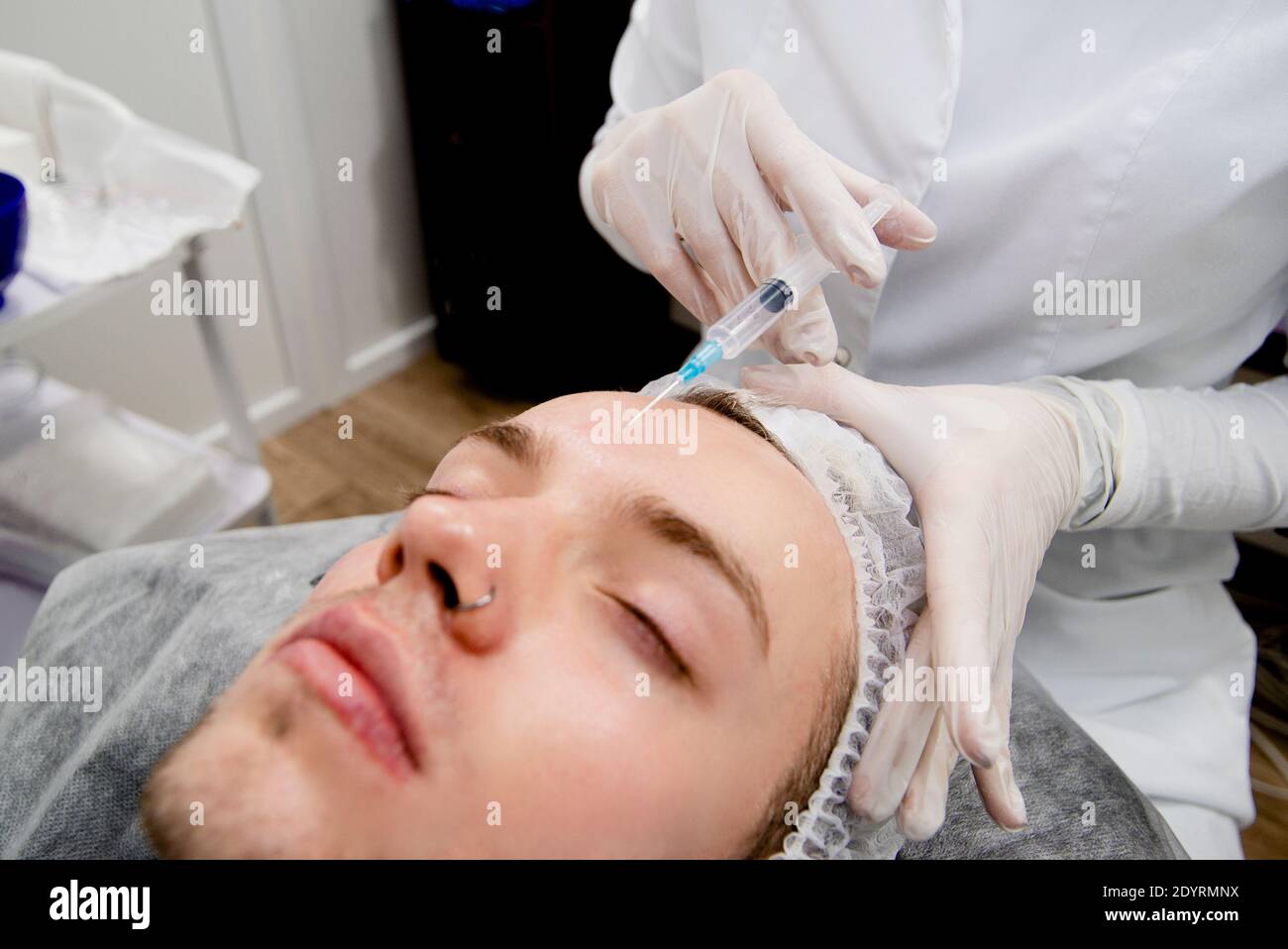 Dermatologe macht Injektionen auf das Gesicht des Mannes, um Narben zu entfernen und Falten und machen es glatt und jung Stockfoto