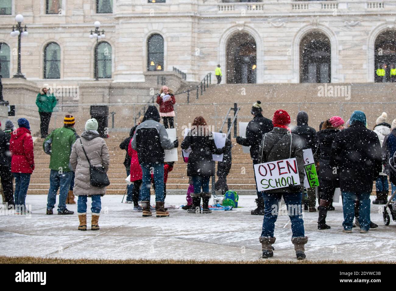 St. Paul, Minnesota. Die Menschen versammeln sich, um die Schulen wieder zu öffnen und Studenten während der Coronavirus-Pandemie an einem verschneiten Tag wieder in den Klassenzimmer zu bringen. Stockfoto