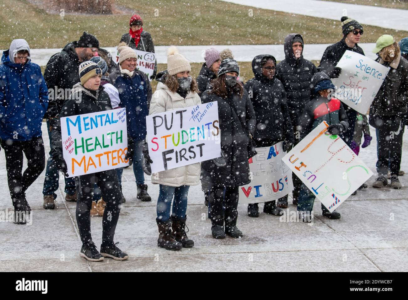 St. Paul, Minnesota. Die Menschen versammeln sich, um die Schulen wieder zu öffnen und Studenten während der Coronavirus-Pandemie an einem verschneiten Tag wieder in den Klassenzimmer zu bringen. Stockfoto