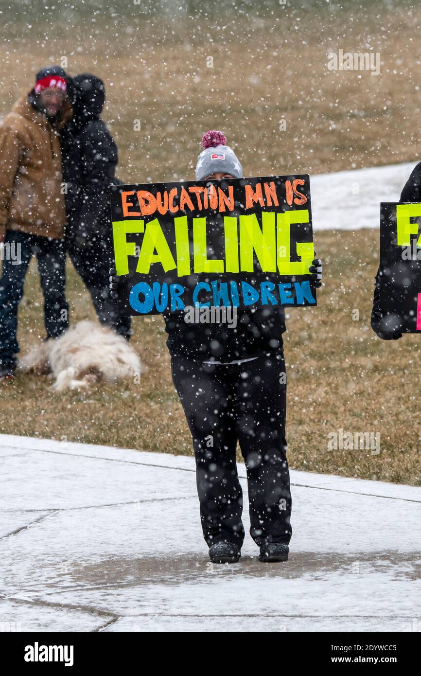 St. Paul, Minnesota. Die Menschen versammeln sich, um die Schulen wieder zu öffnen und Studenten während der Coronavirus-Pandemie an einem verschneiten Tag wieder in den Klassenzimmer zu bringen. Stockfoto