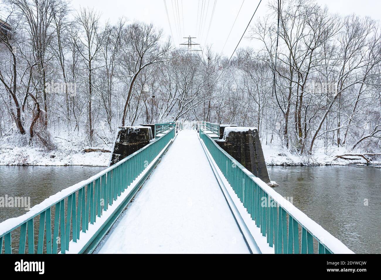 Schneetag, stehend auf einer Brücke über dem Wasser Stockfoto
