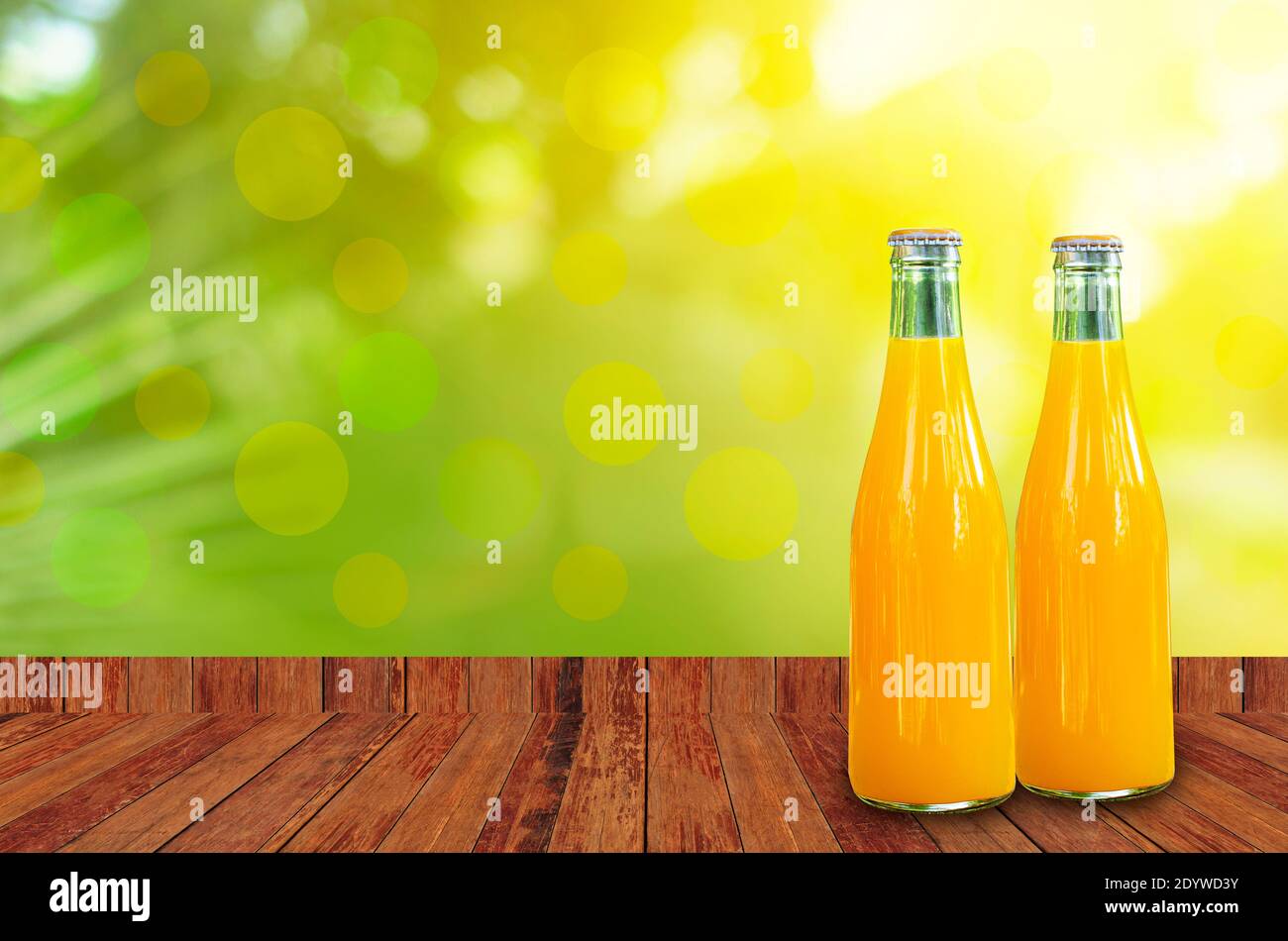Orangensaft in Glasflaschen verpackt Tischplatte aus Holz und grüne Natur Hintergrund Stockfoto