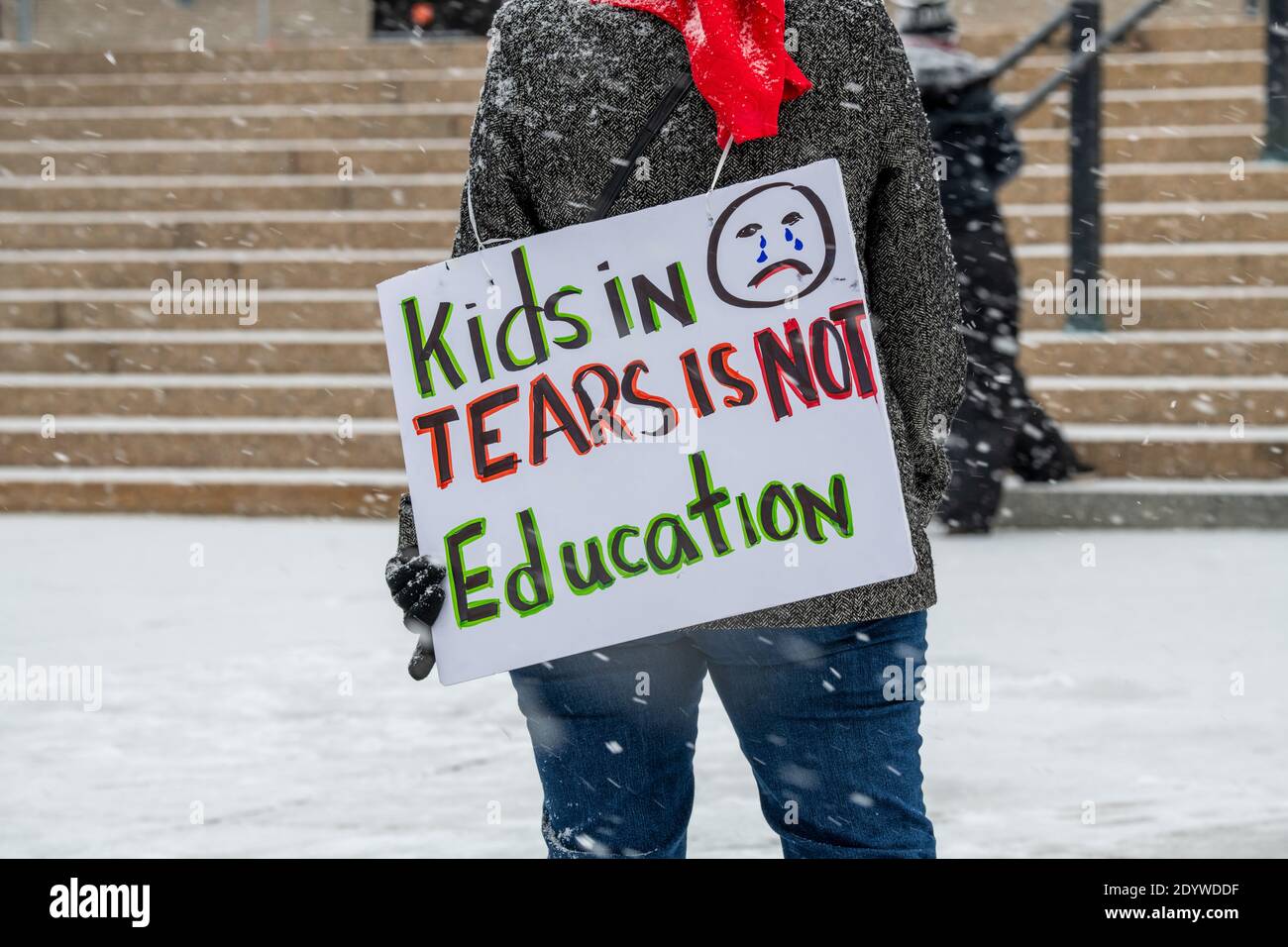 St. Paul, Minnesota. Die Menschen versammeln sich, um die Schulen wieder zu öffnen und Studenten während der Coronavirus-Pandemie an einem verschneiten Tag wieder in den Klassenzimmer zu bringen. Stockfoto