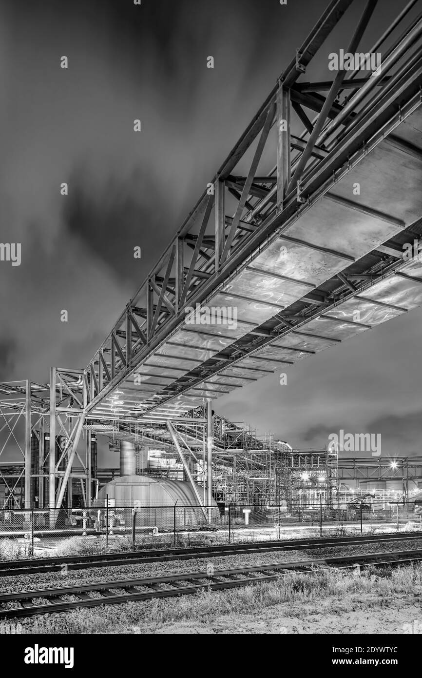 Nachtszene mit Pipeline-Überführung im petrochemischen Produktionswerk, Hafen von Antwerpen, Belgien. Stockfoto