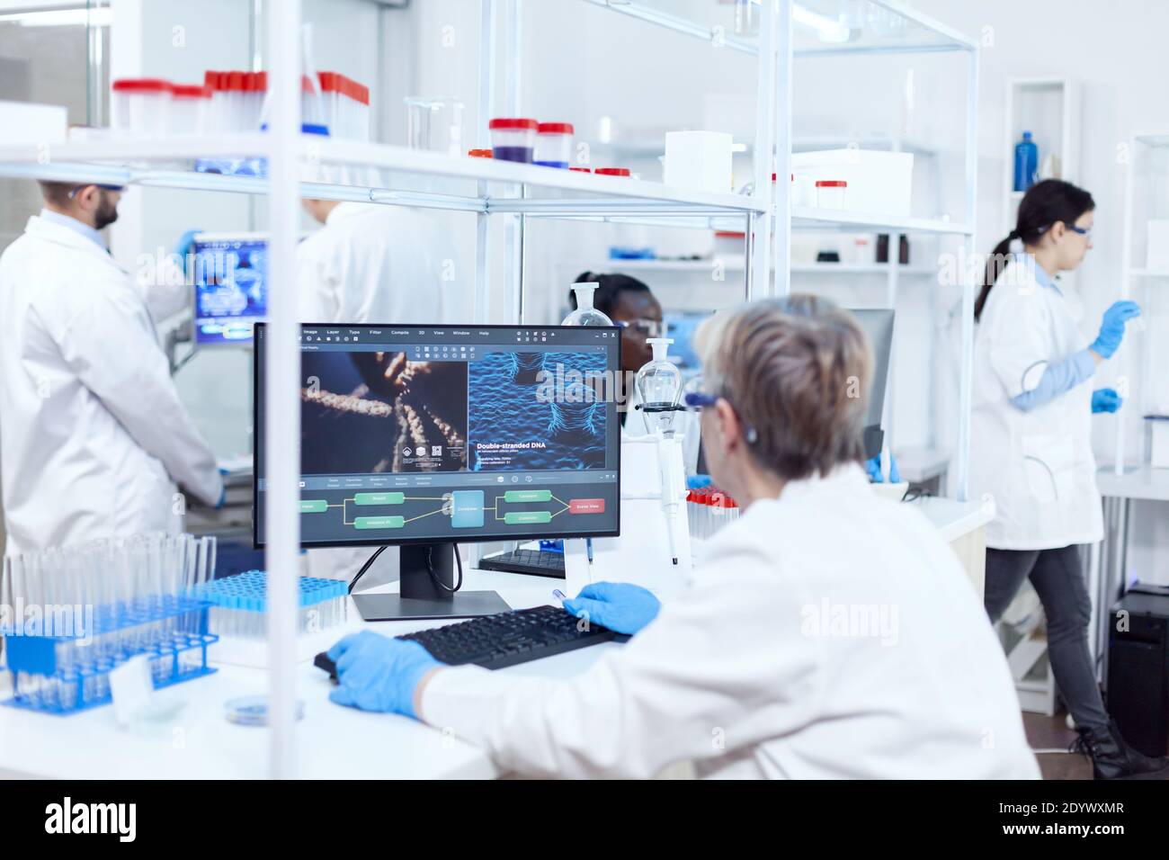 Senior Scientist in Pharmaceuticals Laboratory doing genetische Forschung tragen Labormantel mit Team im Hintergrund. Afrikanischer Assistent Ingenieurswesen adn. Stockfoto