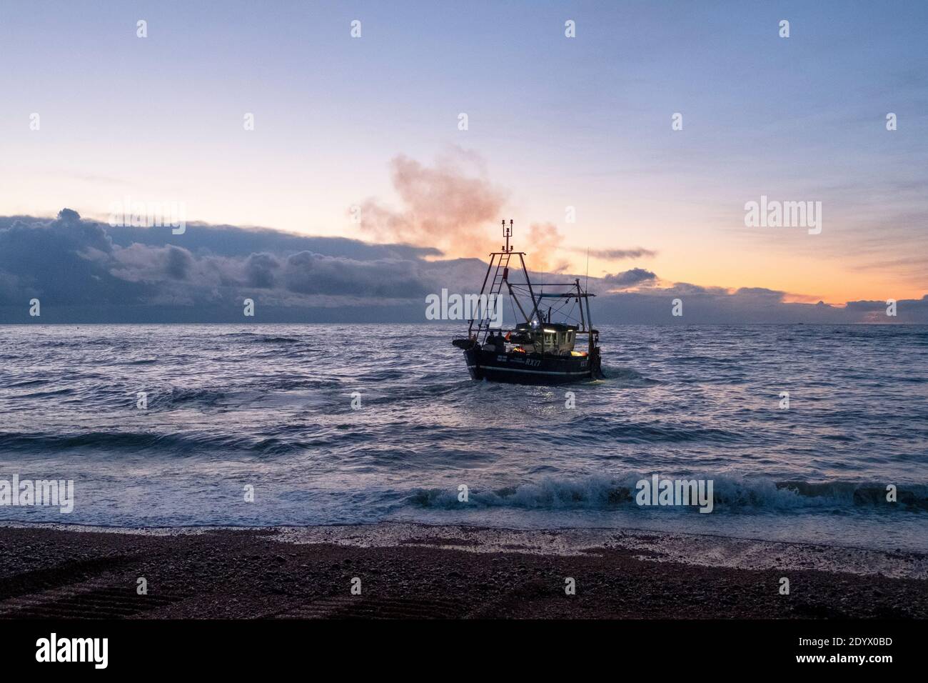 Hastings, East Sussex, Großbritannien 28. Dezember 2020. Hastings Angeltrawler startet in der Morgendämmerung, von der Altstadt Stade Fischer Strand. Mit mehr als 25 Booten verfügt Hastings über die größte am Strand angelaufene Fischereiflotte in Europa. Carolyn Clarke/Alamy Live News Stockfoto