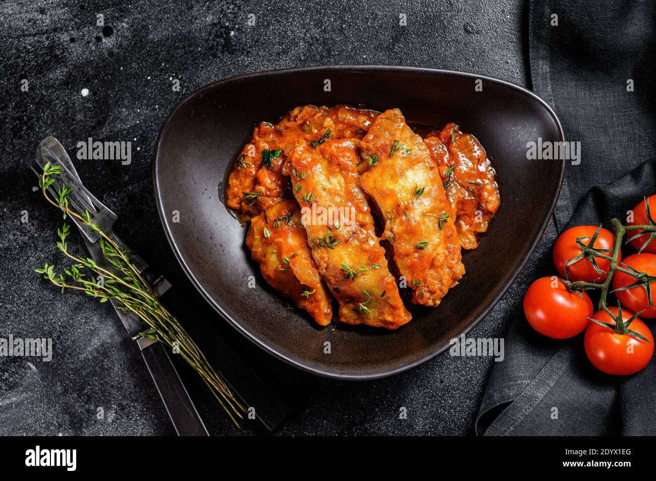 Gebackener Heilbutt-Fisch mit Tomatensauce. Schwarzer Hintergrund ...