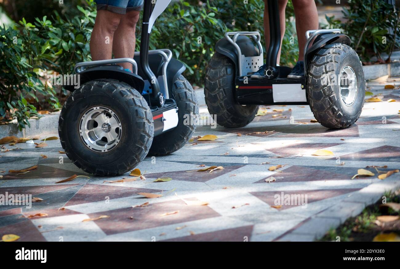 Unterer Teil der einzelnen Elektro-Scooter, die angefahren werden Von Touristen im Park Stockfoto