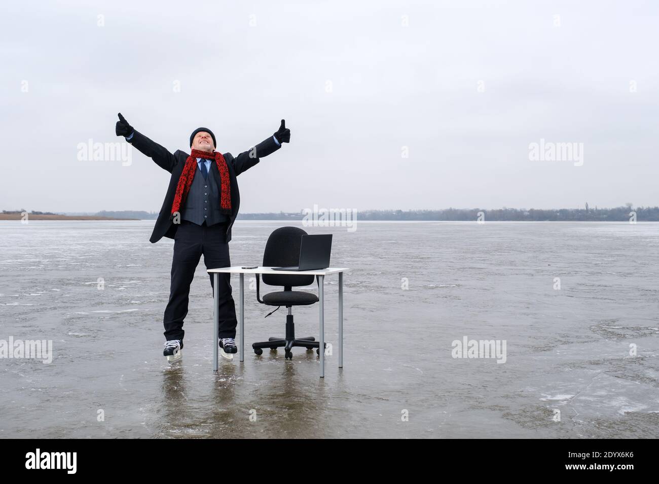 Geschäftsmann im Anzug steht mit ausgestreckten Händen an einem Tisch In der Mitte See Stockfoto
