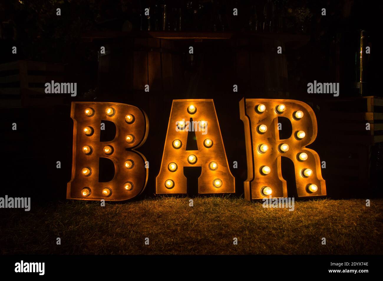 Große leuchtende Buchstaben in der Nähe der Bar. Gelbe Lampen. Stockfoto