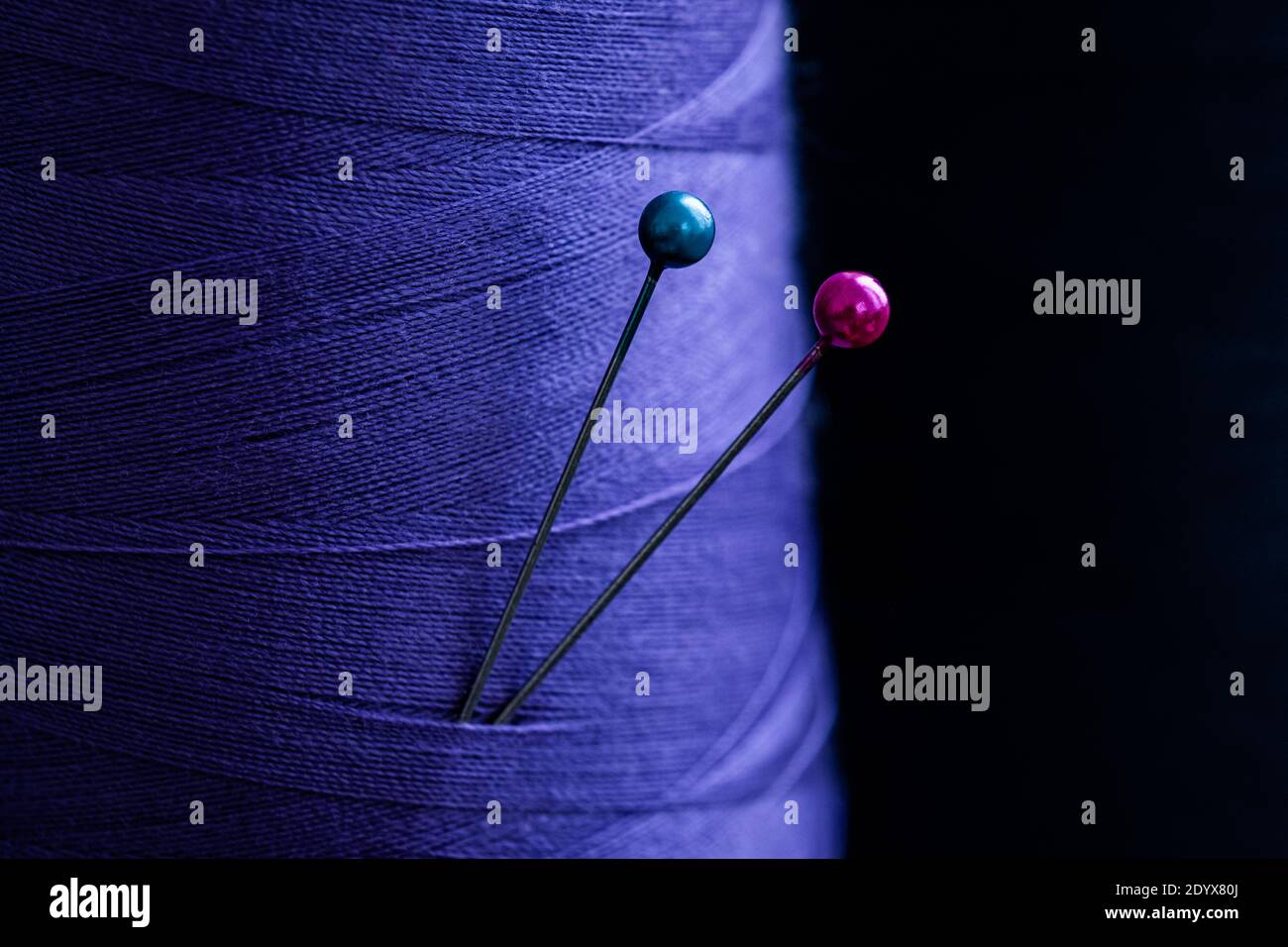 Nahaufnahme der Nähnadeln in blauem Tuch Stockfoto