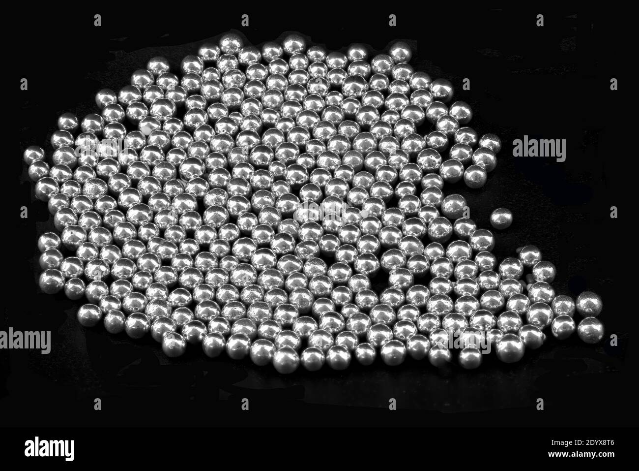 Silberne Sprinkle Dragees auf DUNKLEM Hintergrund.Nahaufnahme Süßwaren kleine silberne Kugellager mit Zucker zur Dekoration beschichtet. Stockbild. Stockfoto