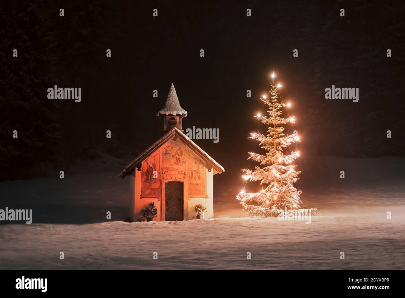 Weihnachtsbaum in der Nähe von winzigen schneebedeckten Kapelle in der versteckt Hölzer Stockfoto