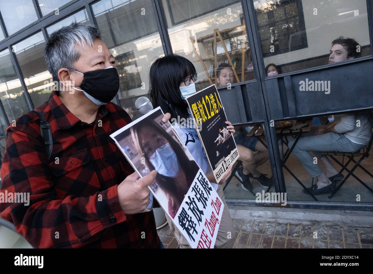 Die Aktivisten Lee Cheuck-yan (L) und Chow Hang-tung (R) halten Plakate mit ihrer Meinung während der Demonstration.Pro-Demokratie-Aktivisten demonstrieren vor Chinas Verbindungsbüro in Hongkong, um die Freilassung von zwölf lokalen jungen Aktivisten zu fordern, die vor einem Prozess auf dem Festland stehen, und der chinesische Staatsjournalist Zhang Zhan. Die zwölf Aktivisten wurden nach einem gescheiterten Versuch, mit einem Schnellboot nach Taiwan zu fliehen, auf dem Festland inhaftiert, während Zhang wegen ihrer Berichterstattung über den Ausbruch des Coronavirus in Wuhan Anfang dieses Jahres zu vier Jahren Gefängnis verurteilt wurde. Stockfoto