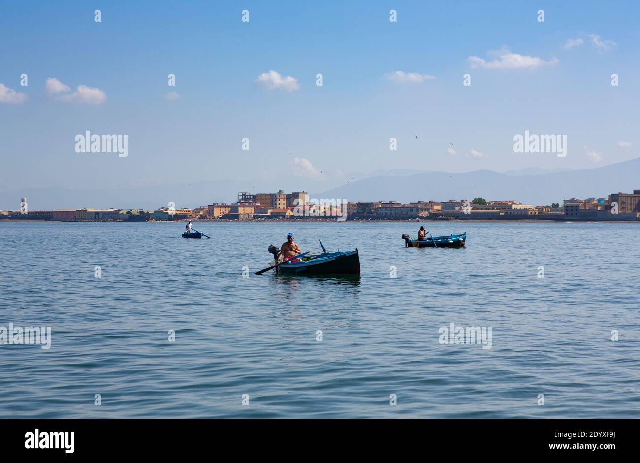 Sorrento, Italien - 2. Juli 2014: An einem klaren und sonnigen Sommertag steuern drei einheimische Fischer ihre Ruderboote in der Bucht von Neapel. Stockfoto