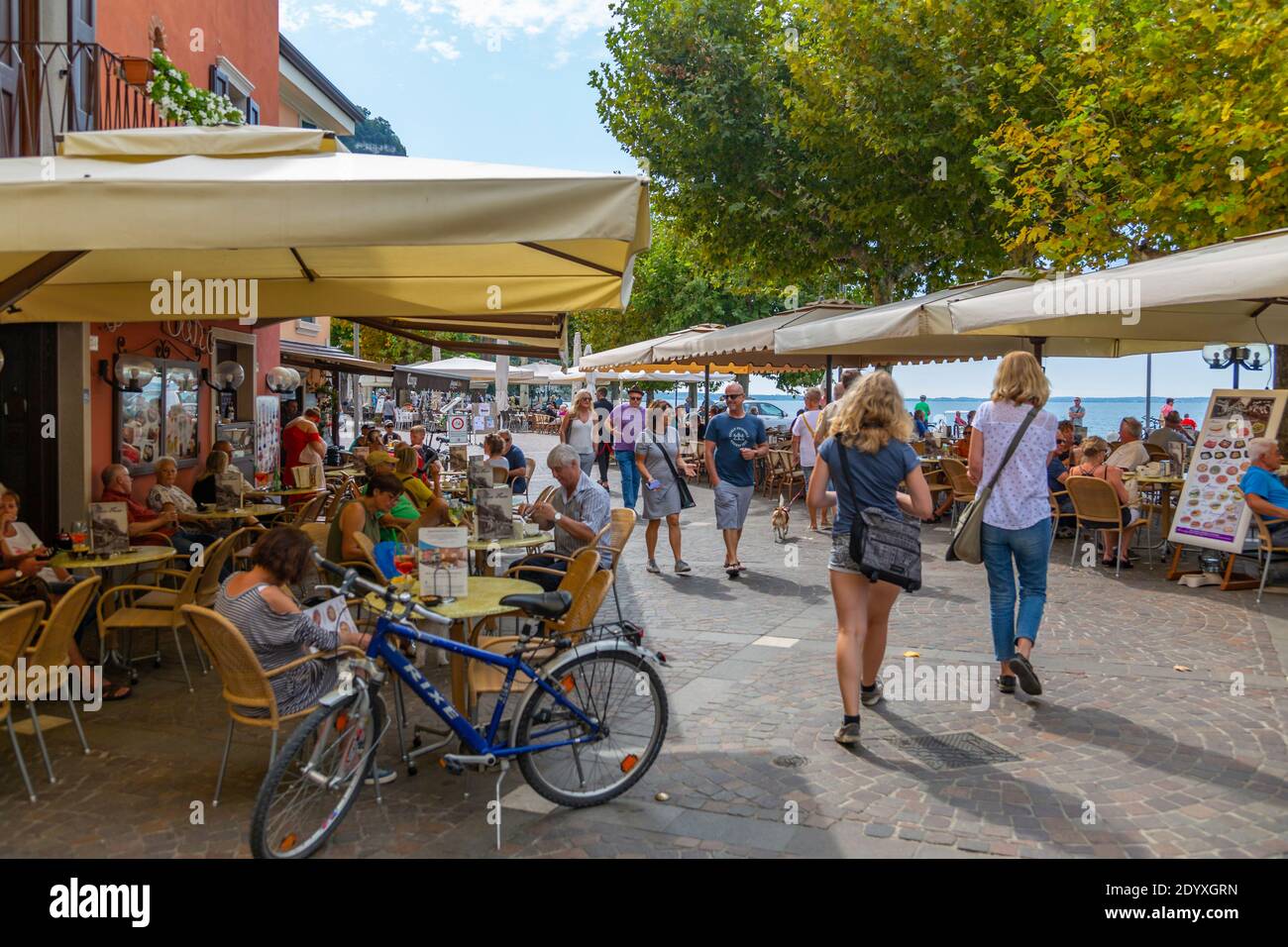 Blick auf Cafés an der Promenade und See an einem sonnigen Tag, Garda, Gardasee, Provinz Verona, Italien, Europa Stockfoto