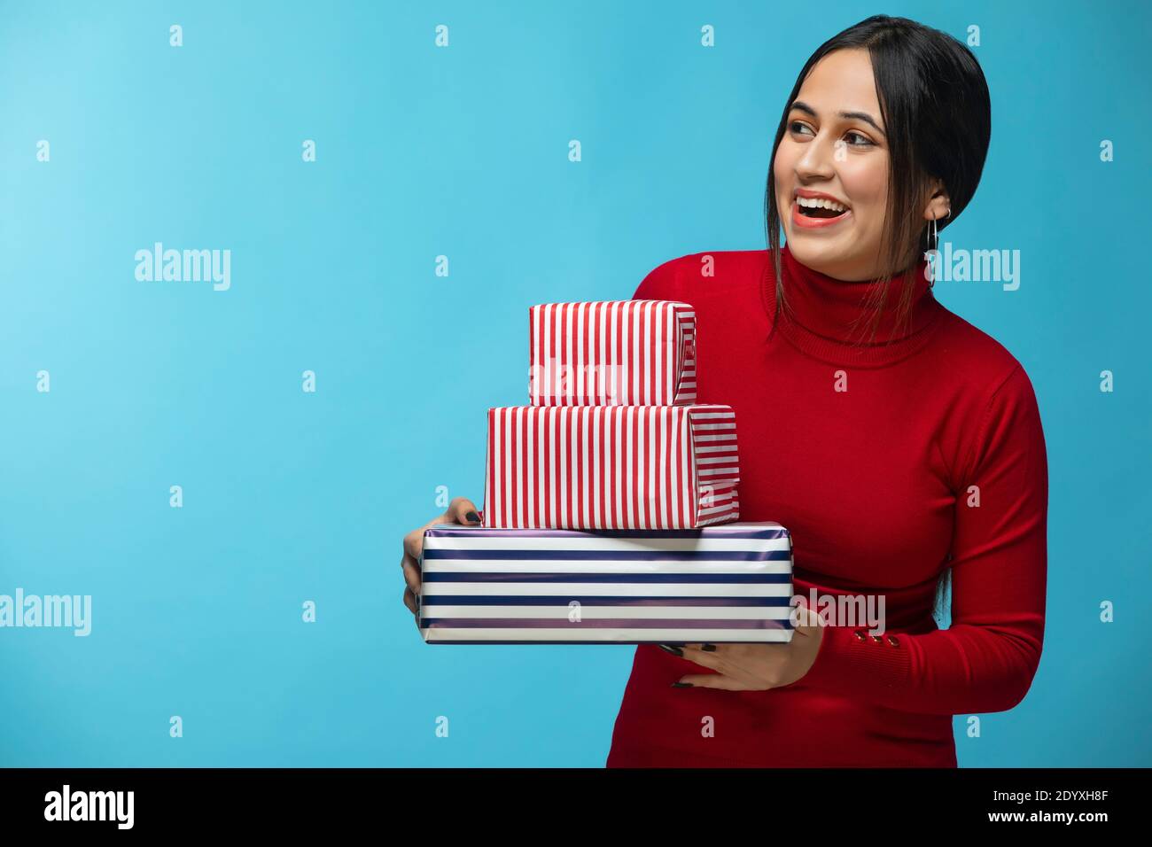 Porträt einer jungen Frau trägt roten Sweatshirt und halten Geschenk Box in der Hand Stockfoto