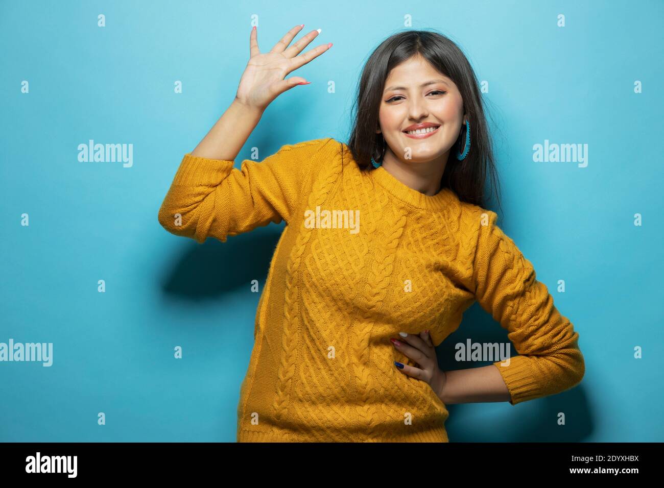 Junge Frau trägt gelben Pullover und tun aufhören zu singen mit Handfläche Stockfoto