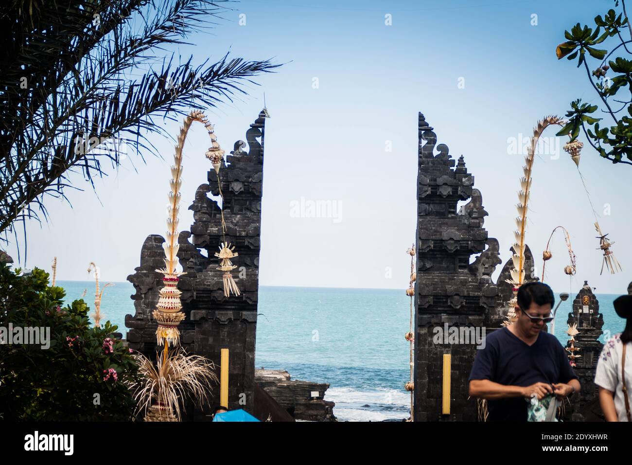 Ein asiatischer Tourist, der durch das Tanah Lot Temple-Tor spazierengeht Auf Bali Stockfoto