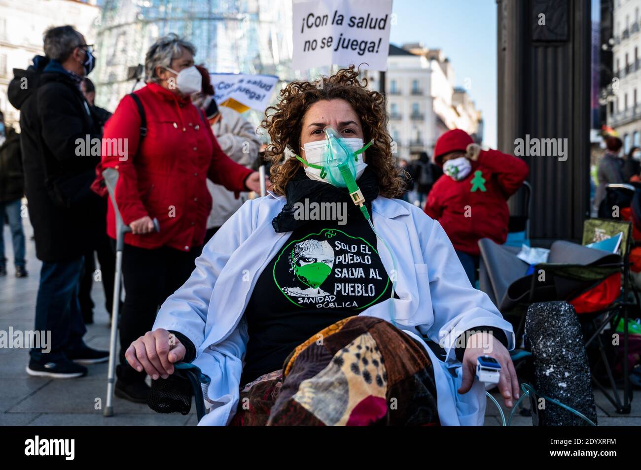 Madrid, Spanien. Dezember 2020. Ein Protestler mit Sauerstoffmaske nimmt an einer Performance gegen das neue Notkrankenhaus Isabel Zendal und gegen die Misshandlung von Gesundheitspersonal während der Coronavirus-Krise (COVID-19) Teil. Mitarbeiter des Gesundheitswesens haben sich auf dem Sol-Platz versammelt, um den "Großen Zirkus des Gesundheitswesens" zu repräsentieren und den Rücktritt der Regionalpräsidentin von Madrid Isabel Diaz Ayuso zu fordern. Quelle: Marcos del Mazo/Alamy Live News Stockfoto