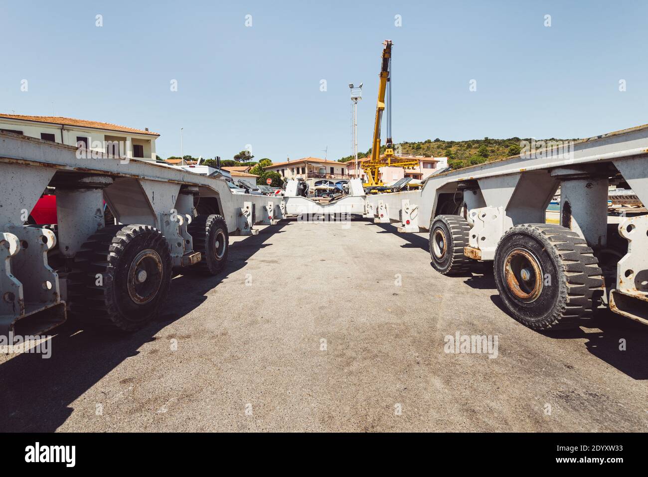 Gelber Teleskopkran und grauer Schwerlasttransporter für Boote und Yachten im Hafen von Talamone, Toskana, Italien Stockfoto