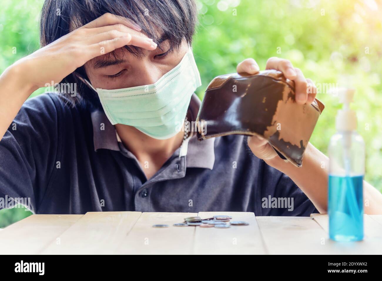 Der Mann pour weniger Medaillengeld aus der Tasche / die Der Mensch war belastet, nachdem covid-19 Situation seine Finanzen zerstören Stockfoto