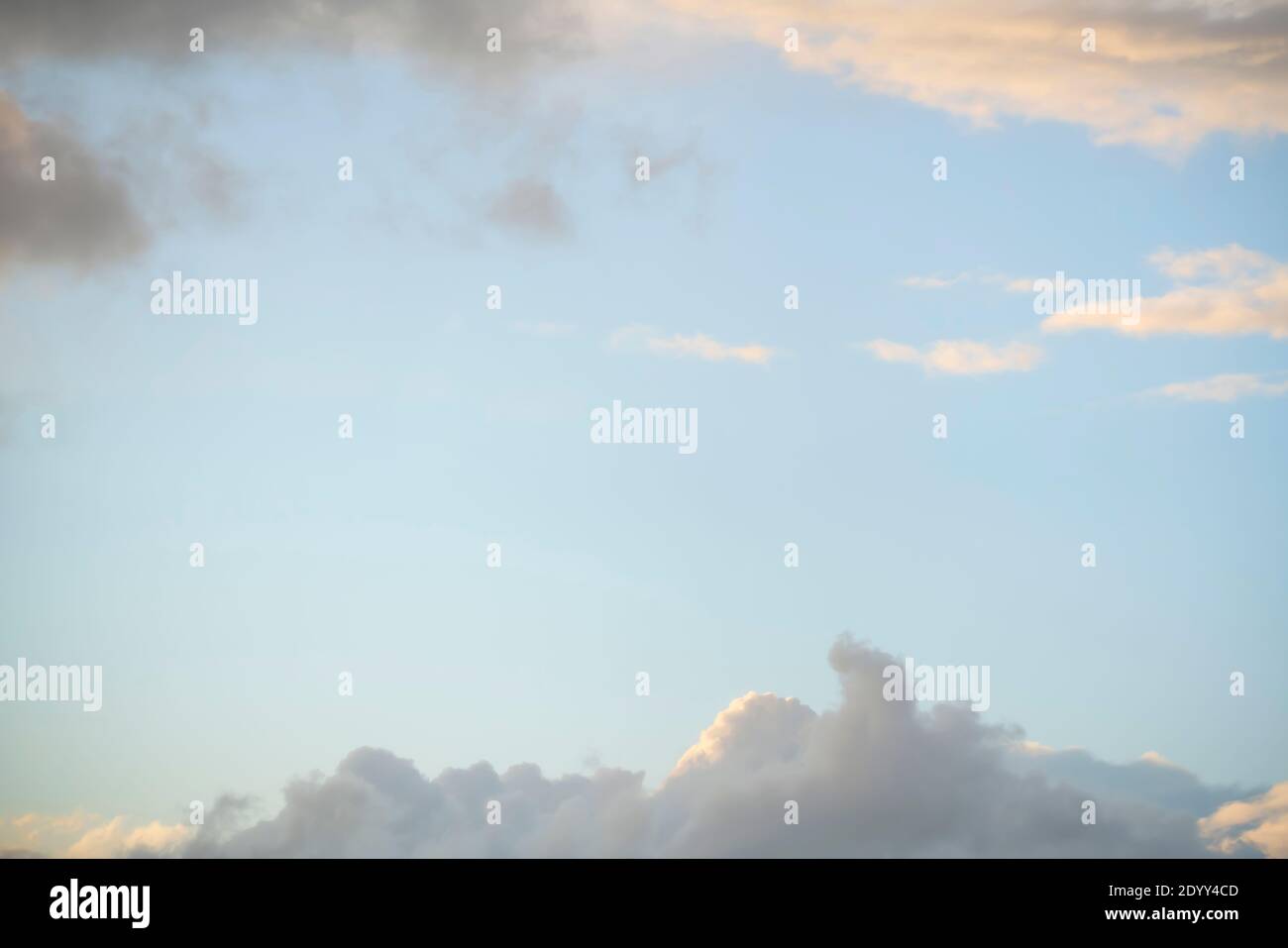 Wolken am Himmel als Rahmen, Sonnenuntergang Textur Hintergrund. Abstrakte Blautöne, Orange und Gelb. Echte hochauflösende Fotografie Stockfoto
